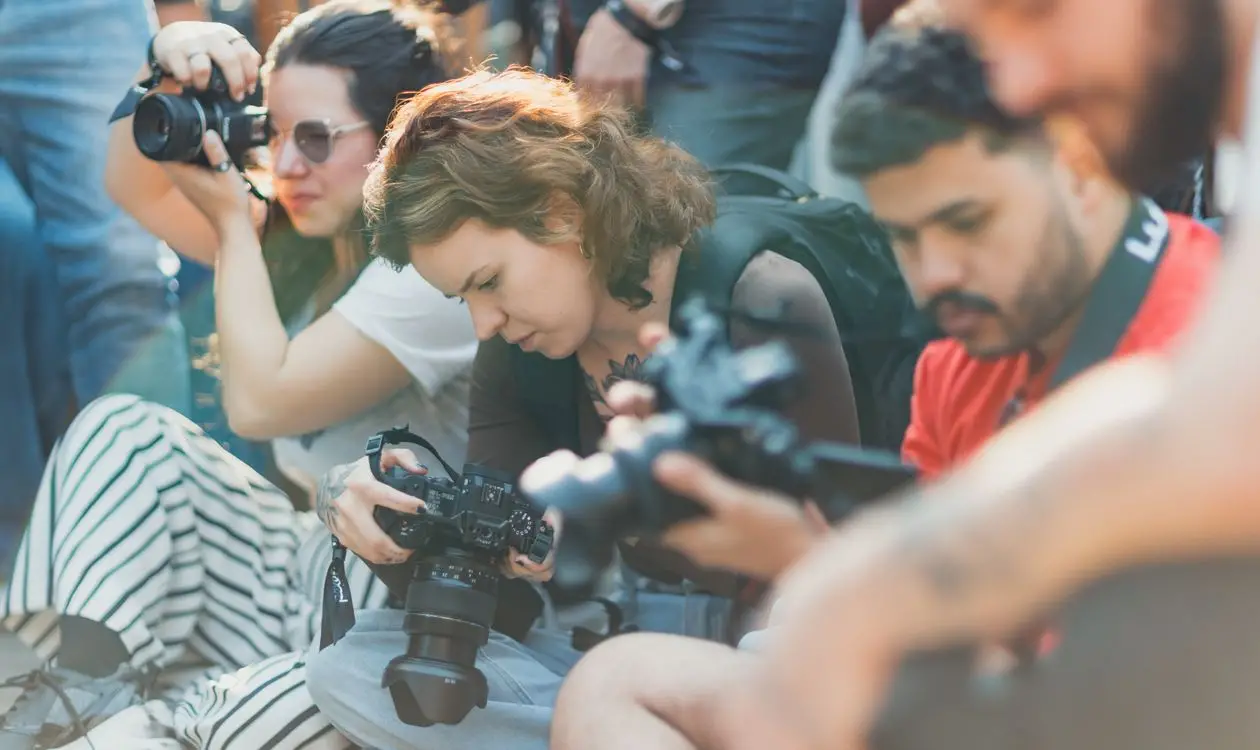 Group of professional photographers with cameras working together at an outdoor corporate event