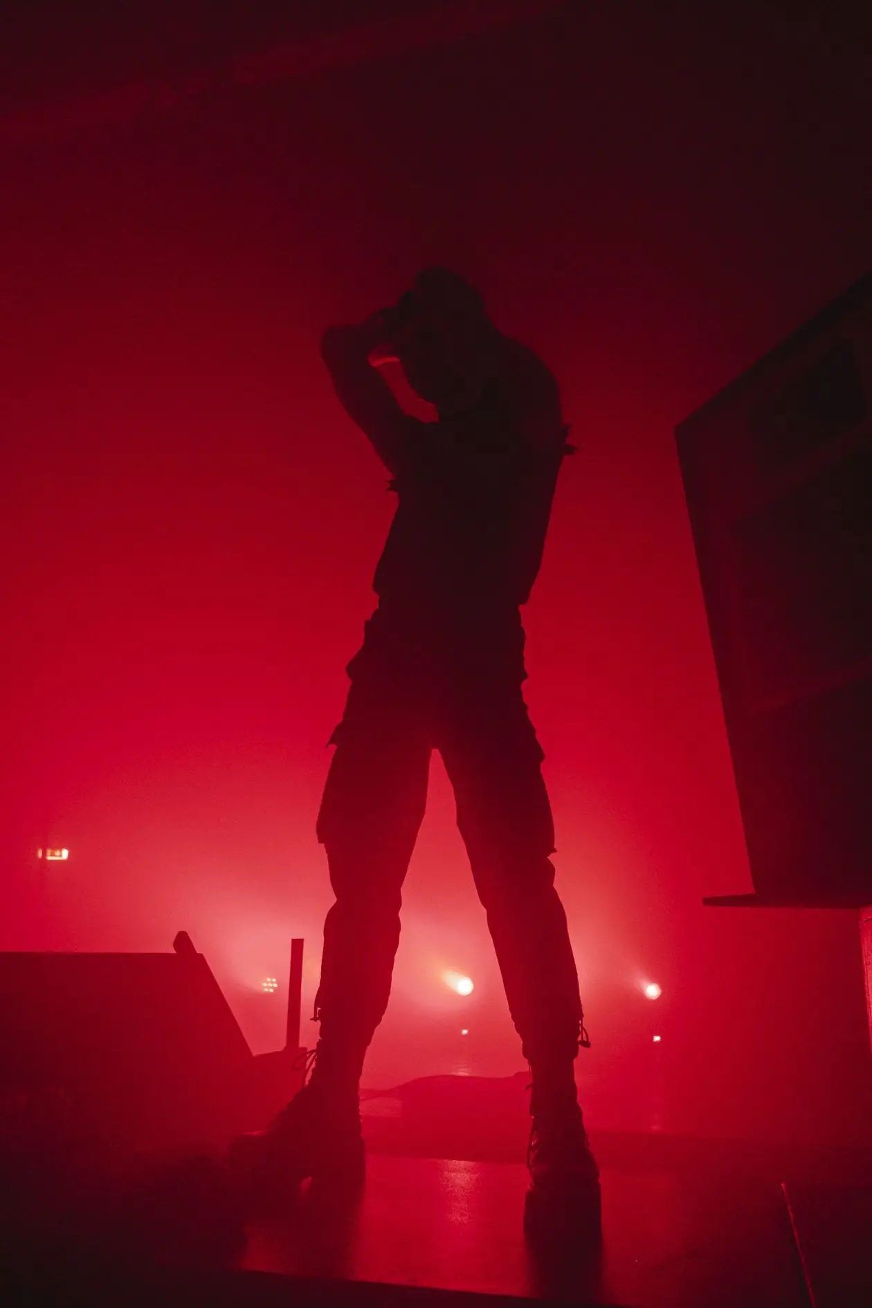 Dramatic silhouette of a presenter on stage under a red spotlight during a product launch reveal