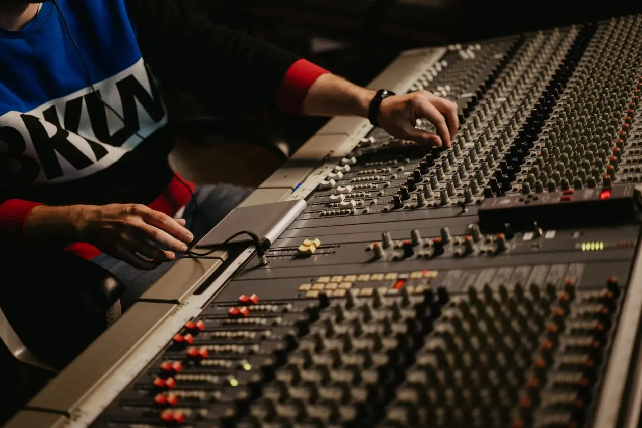 Sound engineer adjusting audio levels on a mixing console during a live production