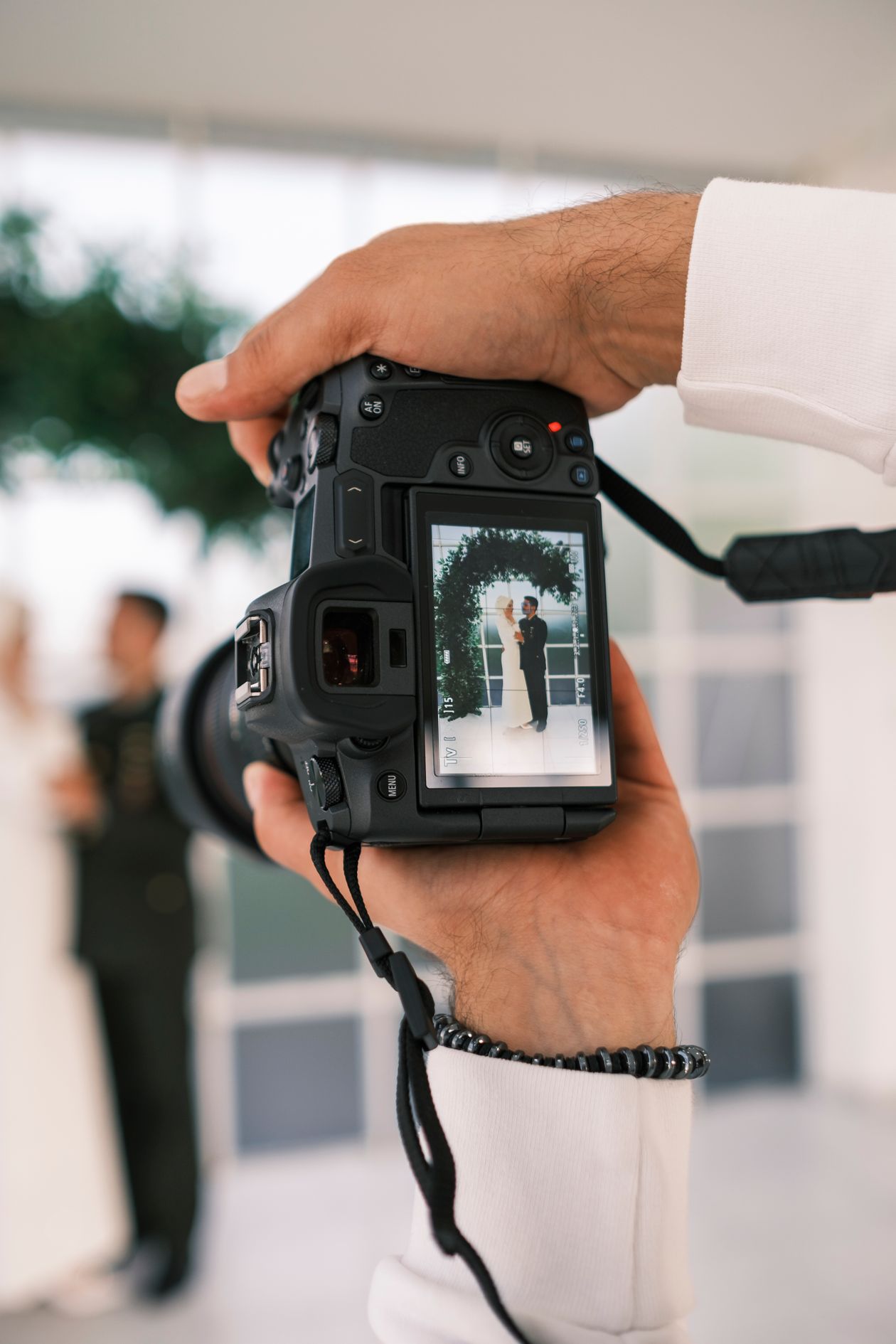 Close-up of a camera viewfinder capturing a bride and groom, wedding videographer camera angle
