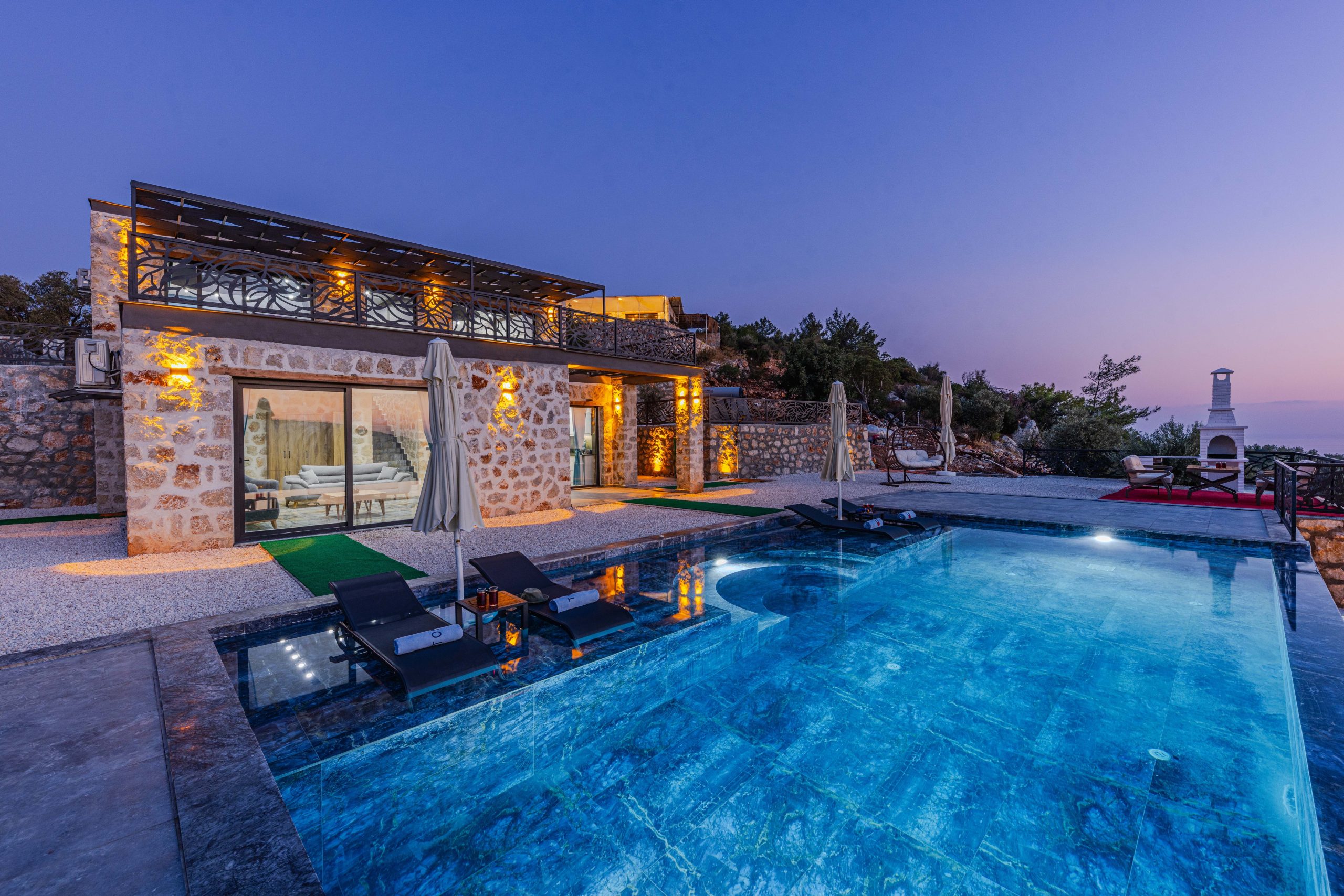 Luxury villa with illuminated pool at twilight, showing twilight real estate photography style