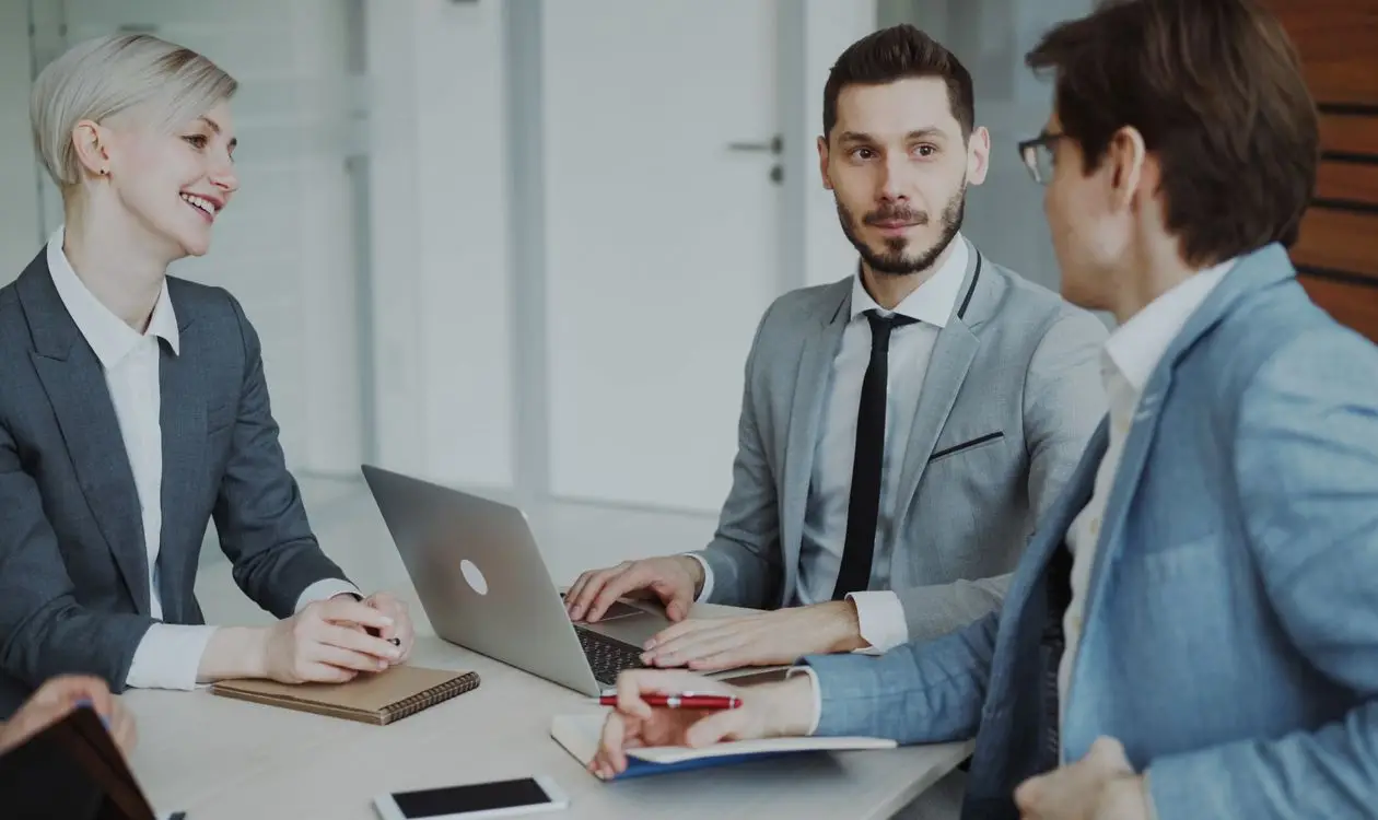 Business professionals in a briefing meeting with laptops and notebooks discussing event planning strategy
