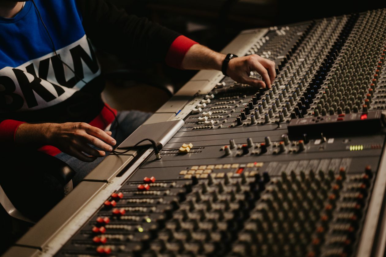 Sound engineer adjusting audio levels on a mixing console during a live production