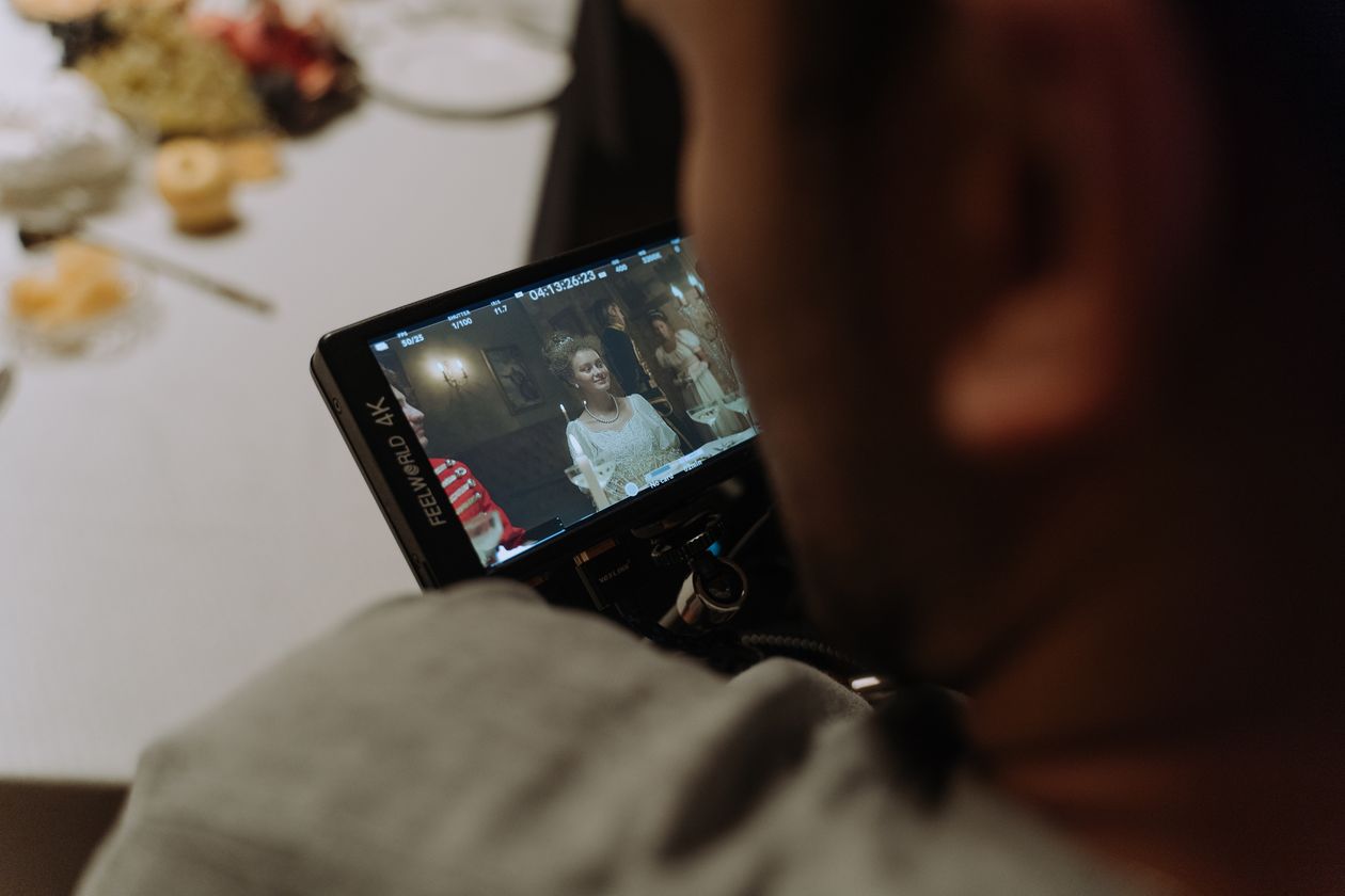 Filmmaker reviewing a scene on a monitor during a shoot, multi-camera production director role