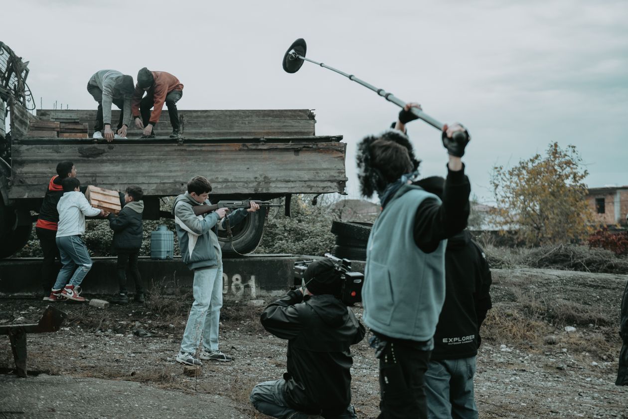 Film crew with multiple camera operators and a boom mic working together on set, multi-camera production crew