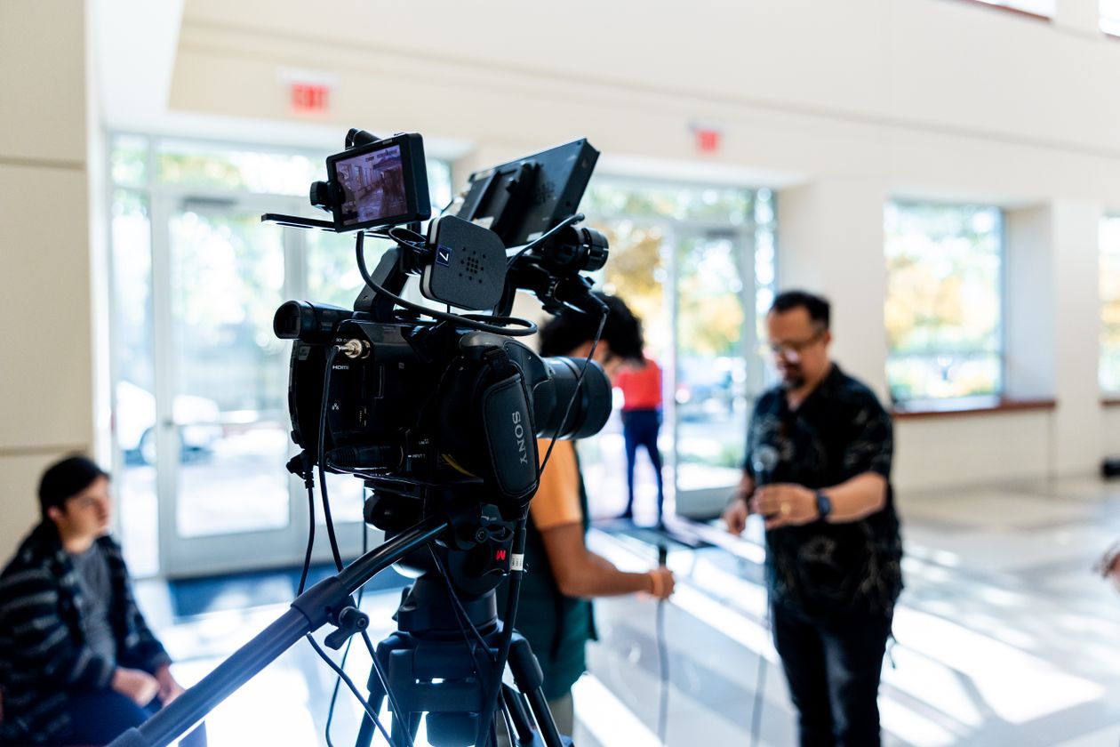 Professional single video camera setup on a tripod at a business event, single-camera coverage